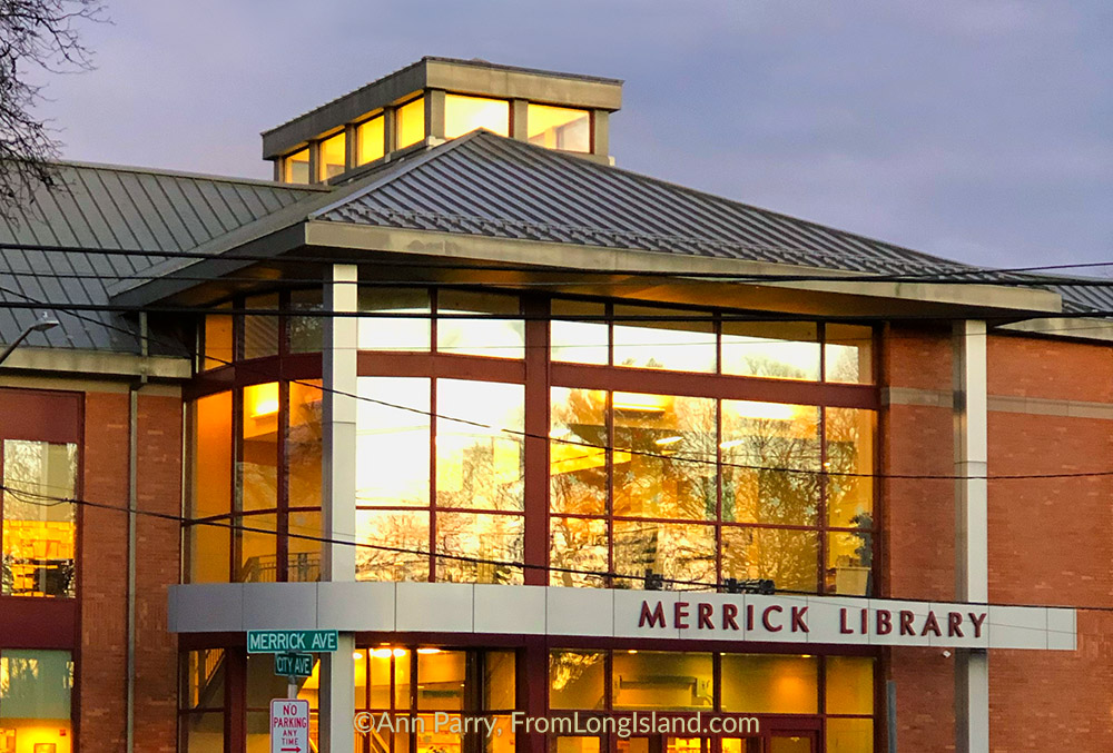 Merrick, New York, USA. January 24, 2019. During winter sunset, golden reflection of trees and building fills windows of Merrick Public Library on south shore of Long Island.