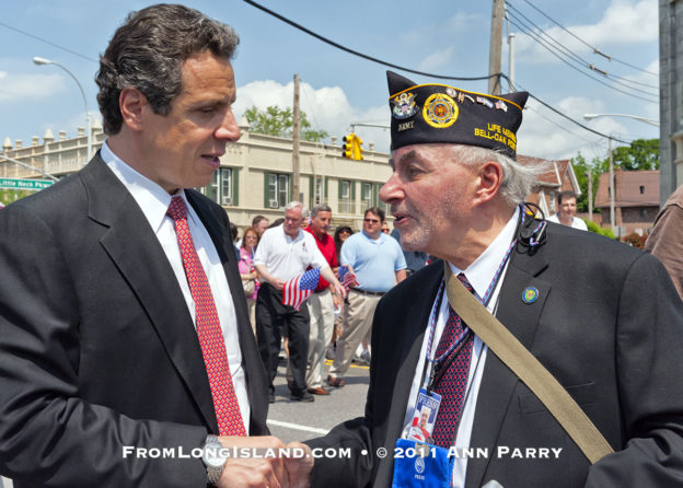 MAY 30, 2011 - Little Neck, New York, U.S. - NY Gov. ANDREW CUOMO stops to speak and shake hands with MARK KOPPELMAN, a U.S. Army veteran wearing US Press Corp Photographer Pass, of Oakland Gardens, during Little Neck-Douglaston Memorial Day Parade, on Northern Boulevard on May 30, 2011. (© 2011 Ann Parry)