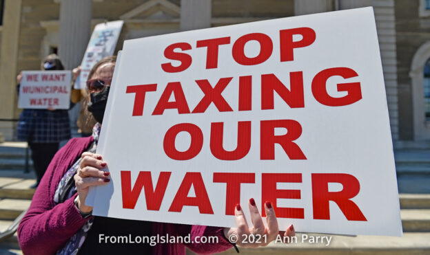 Mineola, New York, USA. April 26, 2021. Activist at rally holds sign saying: STOP TAXING OUR WATER. Faced with a 26% rate increase from New York American Water going into effect May 1, 2021, activists and residents who are NYAW customers rally to urge NYS Assemby to push through legislation, before that date, corresponding with NYS Senate Bill S989A to establish a Nassau County Water Authority and except water works corporations in counties of populations over one million from a special franchise tax. (© 2021 Ann Parry, AnnParry.com)