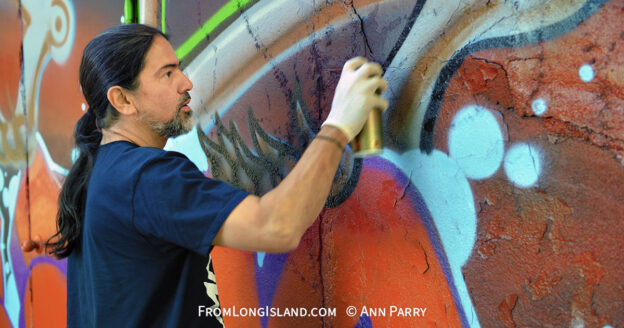 Huntington, N.Y., U.S. August 24, 2013. SONIC BAD, legendary street artist JESSE RODRIGUEZ from the Bronx, is graffiti painting the 'Art Matters' wall, on the back of the Huntington Arts Council building, during the the art event 'Off the Walls' Block Party, by SPARKBOOM. (© 2013 Ann Parry, ann-parry.com)