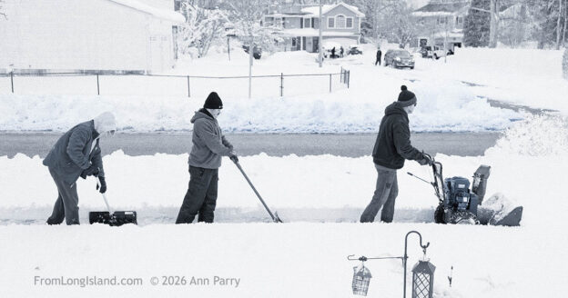 Merrick, New York, U.S., February 23, 2026. Kirk and his two sons shovel their neighbor's home, in the south shore of Nassau County, after a northeast snowstorm dropped about two feet of snow across Long Island.